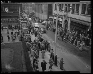 Crowds line the street as cars drive by in front of Charles B. Perkins Co. and Boston's Old City Hall