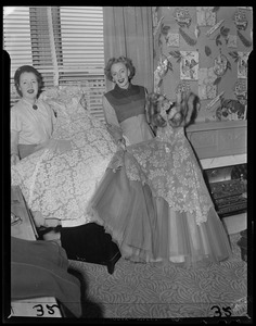 Christine Jorgenson and another woman holding up dresses