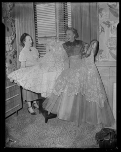 Christine Jorgenson and another woman holding up dresses