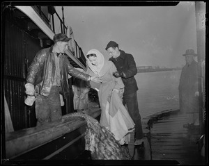 Jennifer Jones boarding a ship with the help of two men