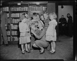 Helen Hayes gives lollipops to John McManus and six other children in a library at St. John's School, Quincy