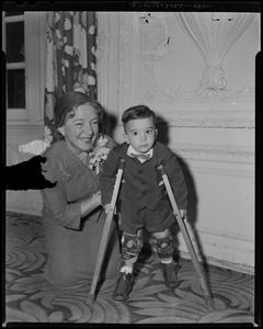 Helen Hayes kneeling next to James M[illegible] of Canton, the State Poster Boy for March of Dimes