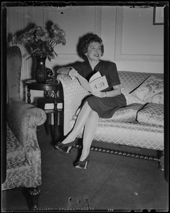 Helen Hayes sitting on a couch and holding a book, "The Ultimate Frog" by Roy Dickinson