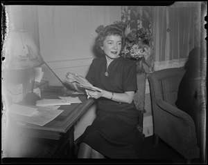 Helen Hayes sitting at desk, holding mail