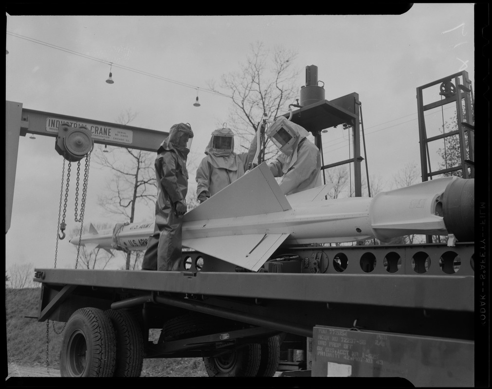 Three men dressed in protection suits with Nike anti-aircraft missile