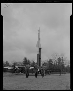 Three military men running from the Nike missile site