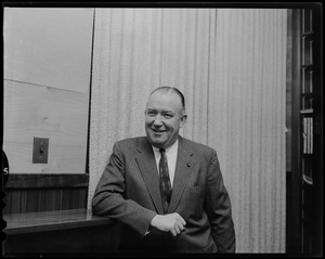 Walter Brown standing, leaning on shelf