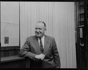 Walter Brown standing, leaning on shelf