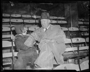 Walter Brown and young child sitting in seats, wearing coats