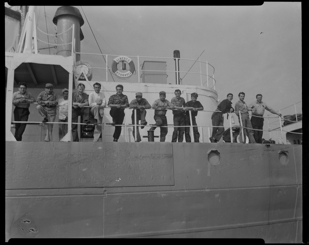 Group of 13 posing on deck of Liberian freighter Alberta, anchored off Cape Cod canal, after Captain Gerasimos Potamianos was overpowered by the crew following his murder attempt on Elefehrios Metaxes