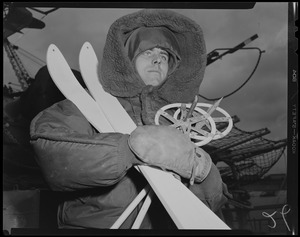 Man holding skis and poles