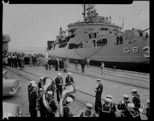 View of the U.S.S. ATKA at the dock from behind a band