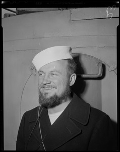 Portrait of a crew member with a beard and a hat