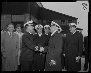 Group of commanding officers meeting outside surrounded by people