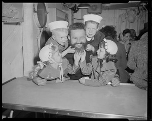 Group of children touching the beard of a crew member