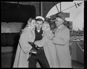 Two women hugging a crew member as another man stands by the women