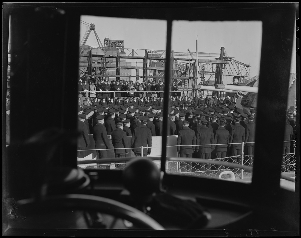 View of the crew onboard the U.S.S. Higbee seen through a window