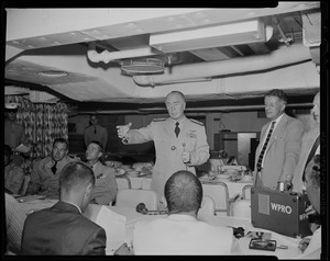 Man in a uniform addressing a room of people