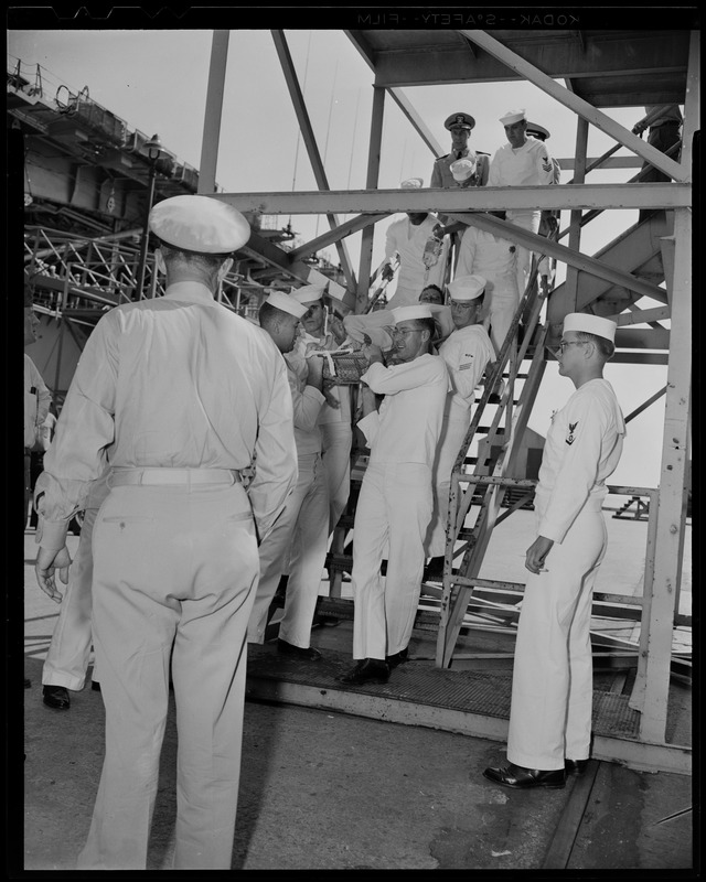 Group of men carrying a man in a stretcher down a set of stairs