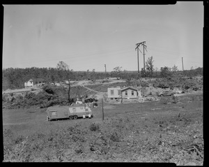 View of an area with a mobile home and two damaged buildings