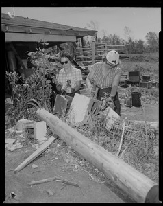 Two women cleaning up wreckage outside