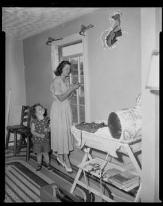 Woman and a child standing beside a window getting ready to do indoor repairs