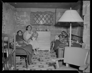 Woman and four children sitting on beds