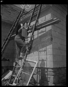 Woman climbing a ladder, carrying roof shingles