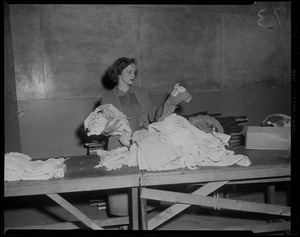 Woman going through clothing drive items