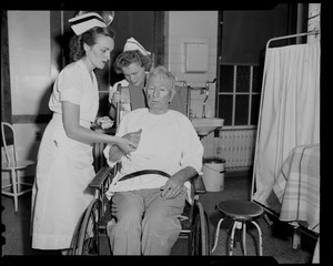 Two nurses with man in wheelchair