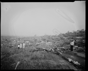 Groups of people assessing damage in field