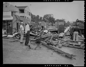 Four men looking at damaged building and wreckage