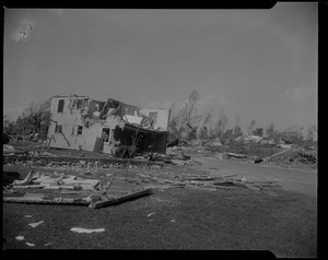 Standing building missing an exterior wall and roof, tilting to the side