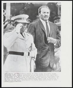 Presidential Review in Congo - Congo President Joseph Kasavubu, left, adjusts spectacles as he and the United Nations representative Mekki Abbas watch military parade in Leopoldville yesterday. Abbas, a Sudanese, is taking place of Rajeshwar Dayal, personal representative of U.N. in New York.