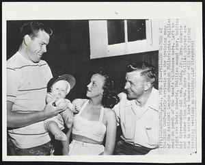 Phillies Gather at Training Camp -- Early arrivals at the training camp of the National League champion Philadelphia Phillies chat on porch of the team's clubhouse here. Left to right are Robin Roberts, Phillies mound star, holding his three-months old son, Robin, Jr., Mrs. Roberts and catcher Stan Lopata. More Phillies players are due to arrive here tomorrow and will start spring training sessions on Saturday.