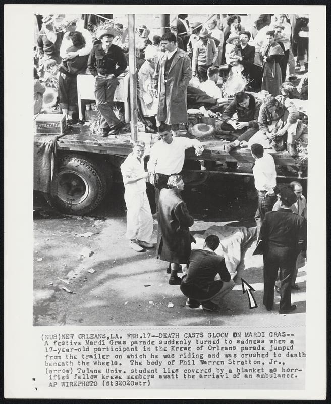 Death Casts Gloom on Mardi Gras-- A festive Mardi Gras parade suddenly turned to sadness when a 17-year-old participant in the Krewe of Orleans parade jumped from the trailer on which he was riding and was crushed to death beneath the wheels. The body of Phil Warren Stratton, Jr., (arrow) Tulane Univ. student lies covered by a blanket as horrified fellow krewe members await the arrival of an ambulance.