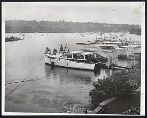 Threatened Again-Louis Lord's cabin cruiser, sunk at Martha's Vineyard during Hurricane Carol, is secured to moorings at the Watertown Yacht Club today in anticipation of Hurricane Edna. Securing the boat are (left to right), Edward Higgins, Tom Theurer, and Albert Lembree.