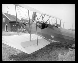 Two unidentified people in a biplane