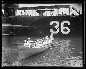 Sailors rowing a boat from a ship numbered "36", the USS Patterson