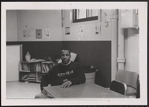 City Year corps member, Markcus, sitting at a table