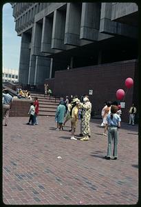 A clown putting a hat on someone's head, Boston City Hall Plaza