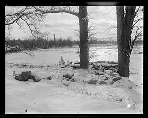 Snow covered rocks by a frozen pond