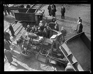 People gather by an overturned truck