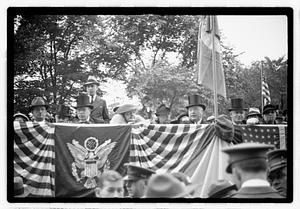 A group of people seated on a reviewing stand including Boston Parks Commissioner William Long