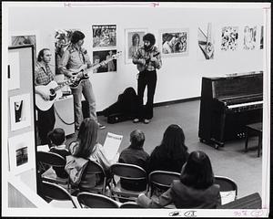 Guitar performance before an audience in the GCC art gallery