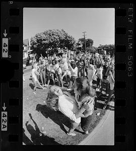 Two women hug while crowd cheers