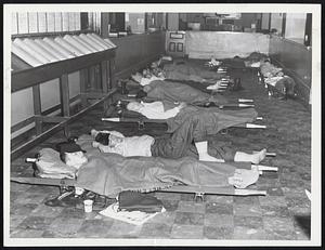 Snow-Stranded commuters took advantage of emergency facilities set up at Boston City Hall. Here the Election Dept. office resembles a dormitory as tired storm victims catch "forty winks.".
