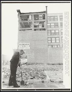 A parking lot attendants sweeps away bricks that fell from the fifth and six floor walls of a business building in downtown Los Angeles during the earthquake that hit the area early 2/9.