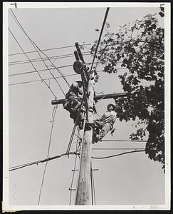 "Trying-On" - High atop a pole in Cambridge trying-on a wire are linemen Frank Farr, left, and Dick Welsh, members of a Central Vermont Power Company crew that answered the distress call and worked with the Cambridge Electric Light Company in restoring power.