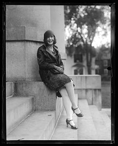 Unidentified woman sitting by a set of steps